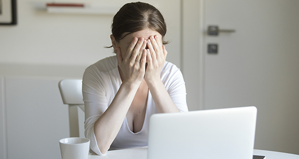 Mujer lamentandose frente a la computadora