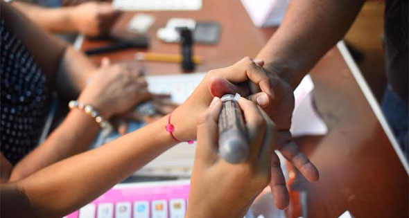 Funcionario de casilla colocando tinta indeleble