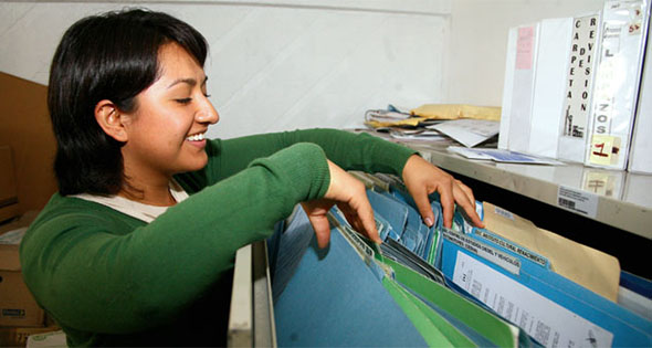 Mujer buscando papeles en archivo